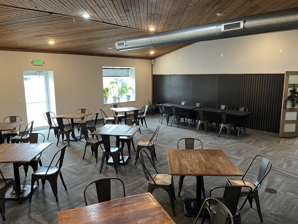 Brew Brothers Coffee event space and community seating in Eldon, Missouri; a spacious local coffee shop interior with industrial decor and large group tables.